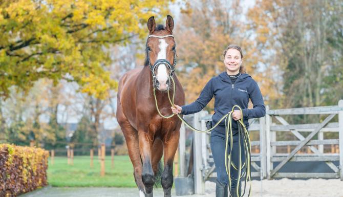 Meisje lopend naast paard