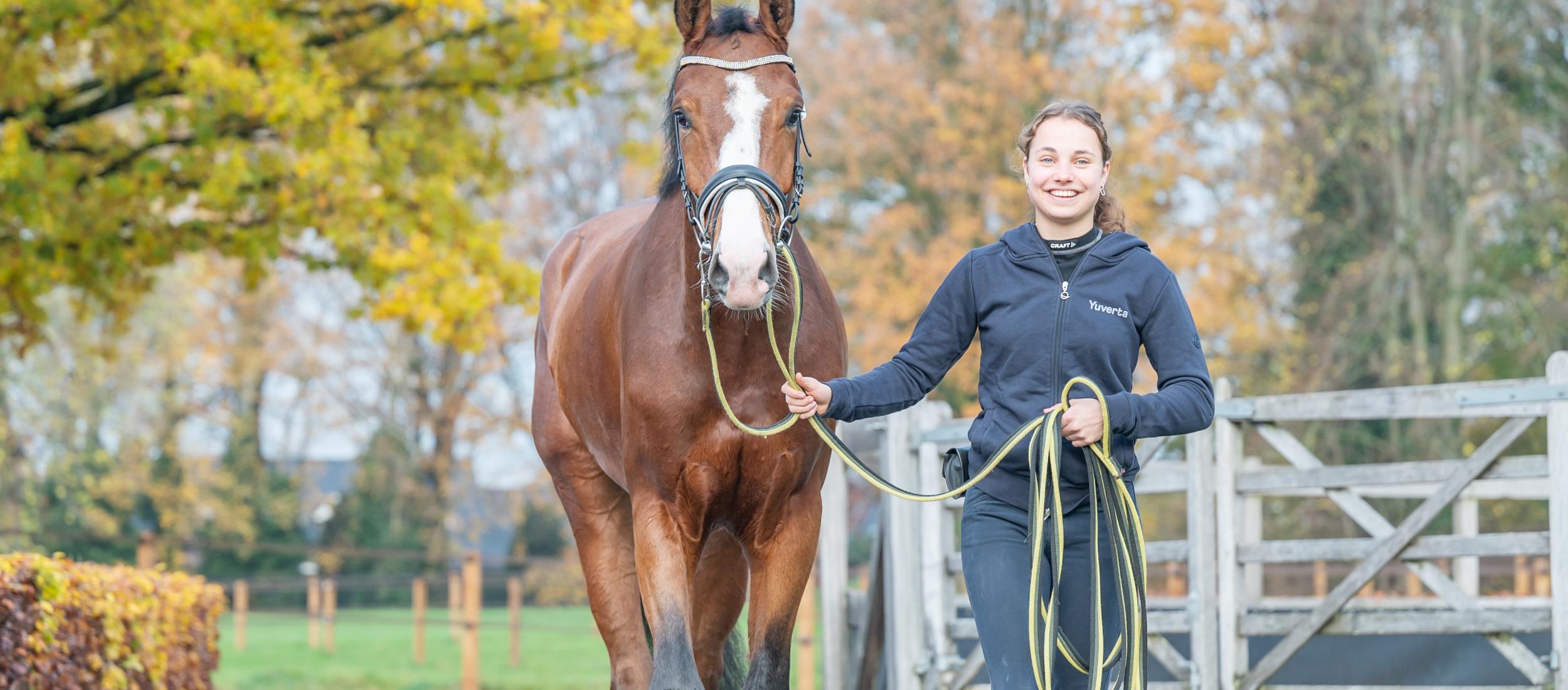 Meisje lopend naast paard